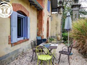 een patio met een tafel en stoelen en een parasol bij Gîte Montbrison, 2 pièces, 2 personnes - FR-1-496-158 in Montbrison