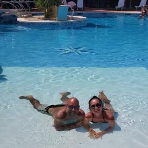 a man and woman swimming in a swimming pool at Ampuria Inn in Empuriabrava