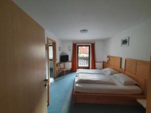 a bedroom with a large bed and a window at ALBERGO BAR RISTORANTE DOLOMIA in Badia
