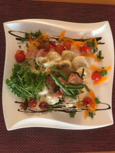 un plato de comida con verduras en una mesa en Hotel-Restaurant zum Donaueck Mauthausen en Mauthausen