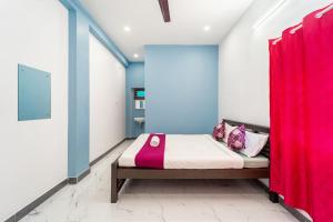 a bedroom with a bed with a red curtain at Pavisha Farm House Swimming Pool in Pondicherry