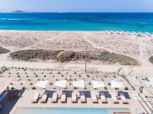 an aerial view of a beach with chairs and the ocean at Ammothines Cycladic Suites in Naxos Chora