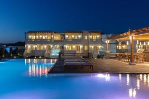 a swimming pool in front of a building at night at Ammothines Cycladic Suites in Naxos Chora