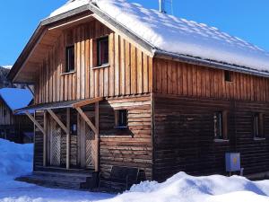 eine Holzhütte mit Schnee auf dem Dach in der Unterkunft Chalet in St Georgen ob Murau with hot tub in Sankt Georgen ob Murau