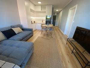 un salon avec un canapé bleu et une table dans l'établissement Apartman in Time - Private Parking - 68m2 - 4 regular beds, à Poprad