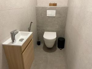 une salle de bain avec des toilettes blanches et un lavabo dans l'établissement Apartman in Time - Private Parking - 68m2 - 4 regular beds, à Poprad