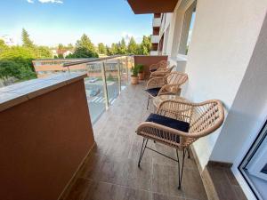 d'un balcon avec des chaises et une vue sur la piscine. dans l'établissement Apartman in Time - Private Parking - 68m2 - 4 regular beds, à Poprad 2 autres photos