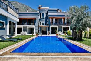 a house with a blue swimming pool in front of it at Nur Suites & Hotels in Kalkan