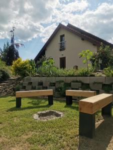 dwie ławki siedzące w trawie przed domem w obiekcie U Tří pecek - Malenice w mieście Malenitz