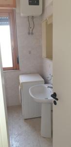 łazienka z białą umywalką i lustrem w obiekcie Residence Mediterranea w mieście Campomarino