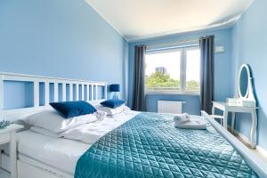 a blue bedroom with a bed and a mirror at EXCLUSIVE Nautica PREMIUM Apartments in Szczecin