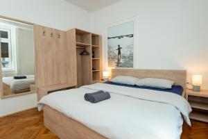 sypialnia z dużym białym łóżkiem i lustrem w obiekcie Viva Rooms w Lublanie