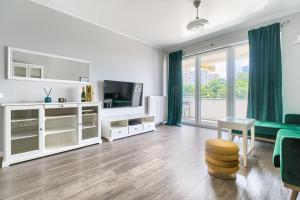 a living room with white furniture and a large window at EXCLUSIVE Nautica PREMIUM Apartments in Szczecin