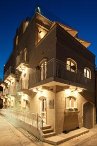 a building with lights on the side of it at Bliss Boutique Living in Xagħra