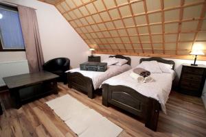 1 Schlafzimmer mit 2 Betten, einem Tisch und einem Stuhl in der Unterkunft Patkószeg Vendégház in Kaposfő