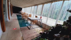 a room with a table and chairs and windows at hotel alismereti in Zekari