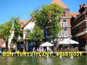 a building with umbrellas next to a body of water at Apartamenty Nowe Mikołajki in Mikołajki