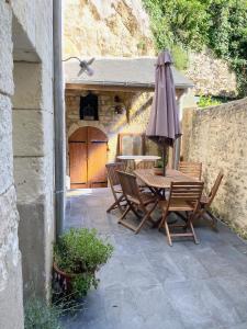 a patio with a table and an umbrella at La Maison des Remparts - Gite 3 etoiles pour 8 pers a Loches in Loches