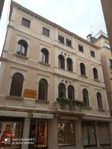 ein großes Gebäude mit vielen Fenstern auf einer Straße in der Unterkunft Ca' Pedrocchi in Venedig