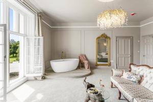 a living room with a bath tub and a chandelier at Welbeck Manor and Golf in Plymouth