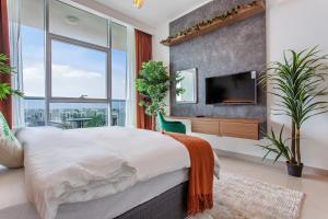 a bedroom with a large bed and a flat screen tv at Live here, enjoy waters of Arabian Gulf in Ras al Khaimah +24 photos