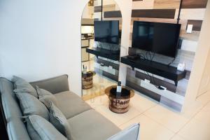 a living room with a couch and a flat screen tv at Wind Residences Condotel in Tagaytay