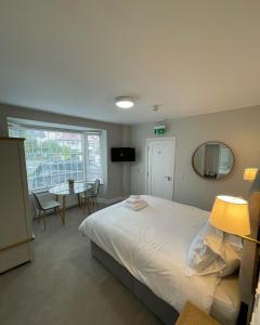 sypialnia z łóżkiem, stołem i lustrem w obiekcie Belvedere House Cork Guest House w Cork