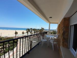 einen Balkon mit Tisch und Stühlen sowie Strand in der Unterkunft Apartamentos Dins Mar Apto. 8 in Torredembarra