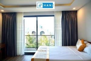 a bedroom with a large bed with a large window at HANZ Sang Sang Hotel Phu Quoc in Phu Quoc