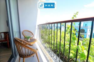 a balcony with two chairs and a sign on the window at HANZ Sang Sang Hotel Phu Quoc in Phu Quoc