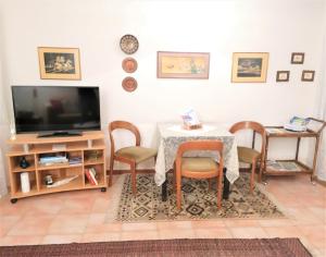 a living room with a table and chairs and a tv at Casa Gisela in Desenzano del Garda