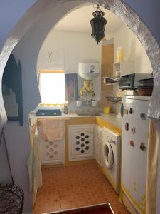 einen Torbogen in einer Küche mit einem Herd und einem Kühlschrank in der Unterkunft HATHOR ,Casa marroquí con dos terrazas en la Medina antigua , ideal parejas!! WIFI!! in Asilah