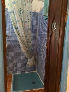 a bathroom with a shower with a blue tiled wall at HATHOR ,Casa marroquí con dos terrazas en la Medina antigua , ideal parejas!! WIFI!! in Asilah