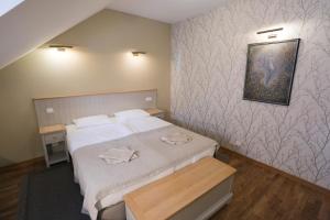 1 dormitorio con 1 cama y una foto en la pared en Hotel Jonapolis en Jonava