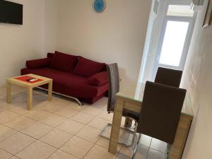 a living room with a red couch and a table at Apartments Bojanic in Bar