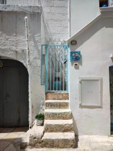 ポリニャーノ・ア・マーレにあるLa Casa Di Nicoleの青い門のある階段のある建物