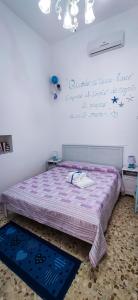 ポリニャーノ・ア・マーレにあるLa Casa Di Nicoleのベッドルーム(紫色の掛け布団付きのベッド1台付)