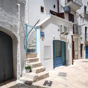 a white building with a blue door and stairs at La Casa Di Nicole in Polignano a Mare +128 photos