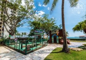 a resort with palm trees in front of a building at Port Dickson 10Pax 3BR Glory Beach Resort Seaview in Port Dickson
