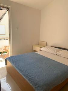a bedroom with a bed with a blue blanket on it at Apartments Lampion in Vir