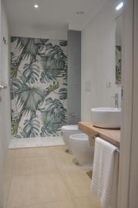 a bathroom with two sinks and two toilets and a shower at Clori in Pescia Romana