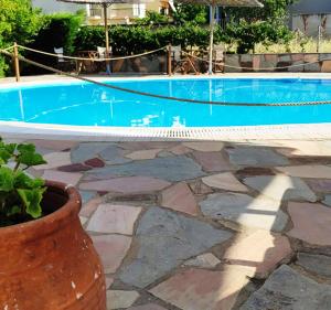 a swimming pool with a stone floor and a vase at Villa Riviera in Stavros