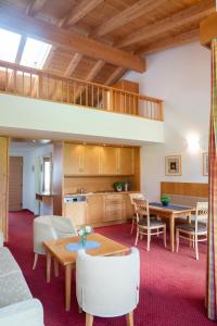 Aparthotel Schindlhaus/Alpin في سول: غرفة معيشة مع طاولات وكراسي ومطبخ