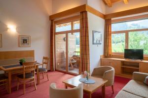 a living room with a couch and a table and a tv at Aparthotel Schindlhaus/Alpin in Söll