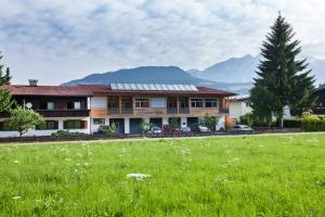 a house with a green field in front of it at Aparthotel Schindlhaus/Alpin in Söll
