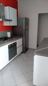 La cuisine est équipée de placards blancs et d'un réfrigérateur en acier inoxydable. dans l'établissement Residenza Re Umberto, à Civitanova Marche