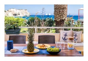 a wooden table with plates of food and fruit on it at Beachfront Blue apt-Ligaria beach in Lygaria