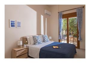 Schlafzimmer mit einem Bett mit blauer Bettwäsche und einem Balkon in der Unterkunft Beachfront Blue apt-Ligaria beach in Ligaria