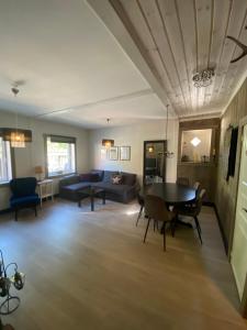 - un salon avec une table, des chaises et un canapé dans l'établissement Kvamseter Lodge private family apartment, à Kvam