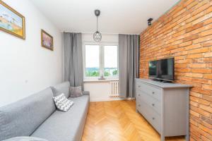 Televízia a/alebo spoločenská miestnosť v ubytovaní Przytulny Apartament 3city z Dwiema Sypialniami w Gdyni by Noclegi Renters